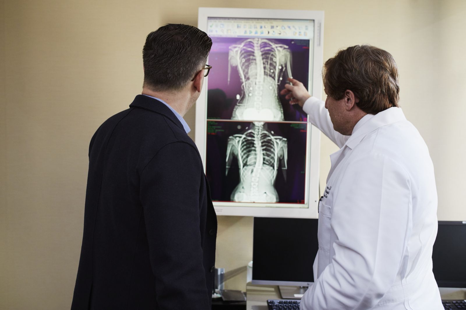 A doctor explains a spine X-ray to a patient